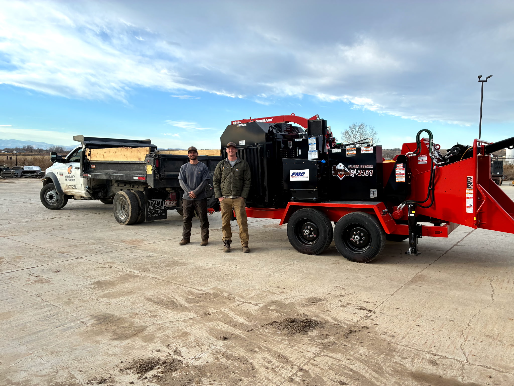 Ben and Jack of Mammoth Mitigation standing in front of their wood chipper